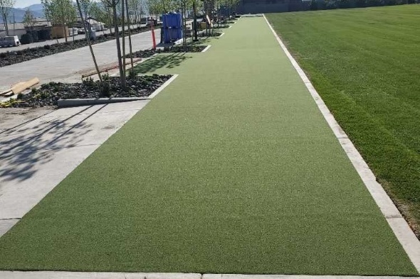 Austin Outdoor tee line consisting of one continuous green synthetic grass strip surrounded by trees